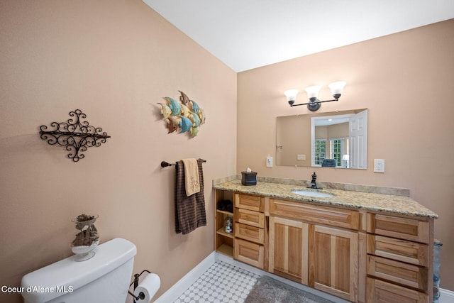 bathroom featuring lofted ceiling, toilet, vanity, and baseboards