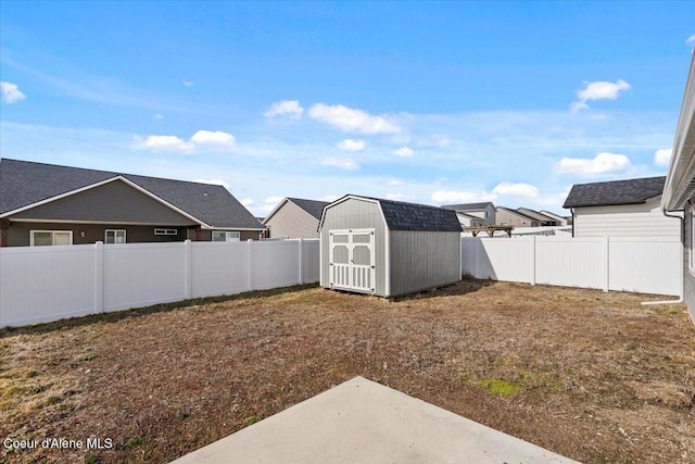 view of yard with an outbuilding, a storage unit, and a fenced backyard