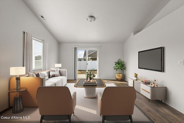 living room with a wealth of natural light, wood finished floors, and vaulted ceiling