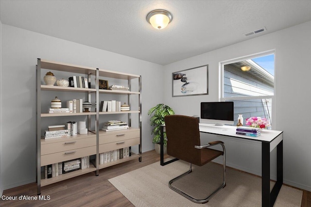 office area featuring visible vents, a textured ceiling, and wood finished floors