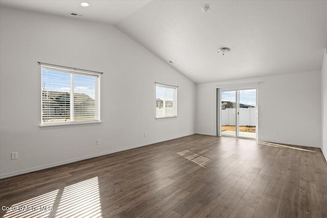 unfurnished room with visible vents, baseboards, lofted ceiling, and wood finished floors