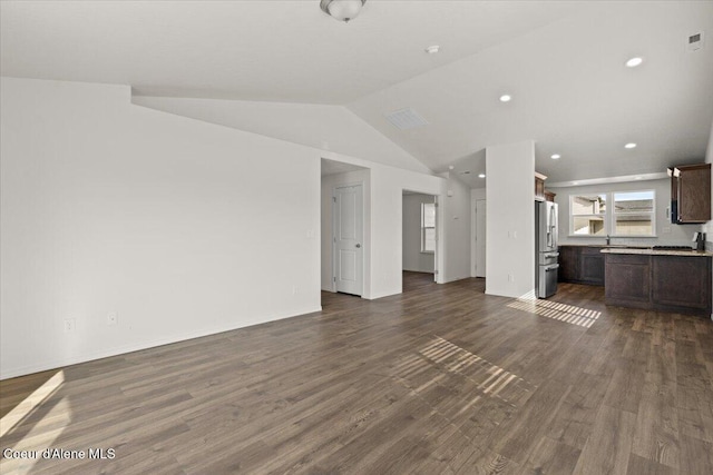 unfurnished living room with recessed lighting, baseboards, dark wood-type flooring, and vaulted ceiling