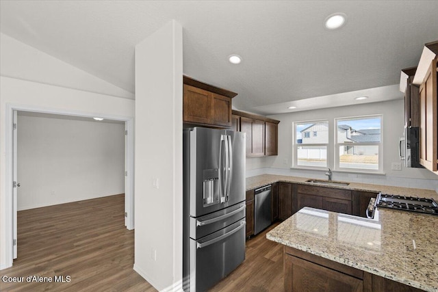 kitchen with a sink, stainless steel appliances, light stone countertops, and dark wood-style flooring