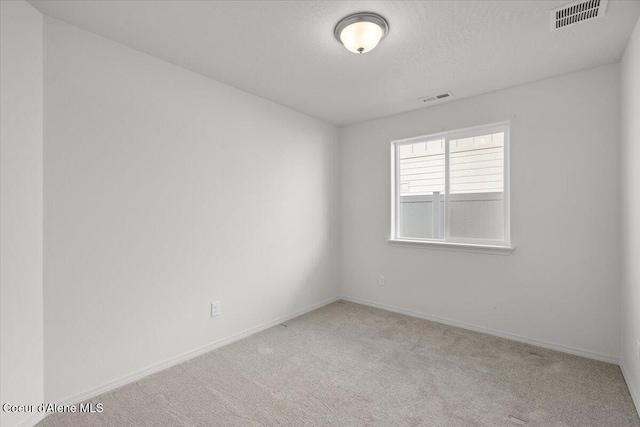 unfurnished room featuring baseboards, visible vents, carpet floors, and a textured ceiling