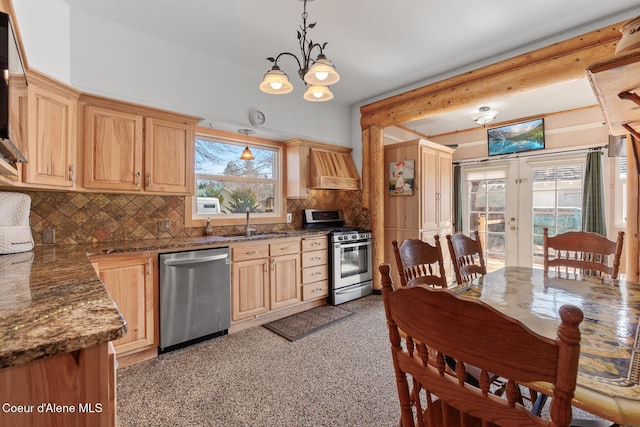 kitchen featuring premium range hood, a sink, french doors, appliances with stainless steel finishes, and backsplash