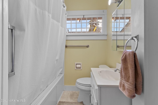 full bathroom with tile patterned floors, toilet, shower / bath combination with curtain, baseboards, and vanity