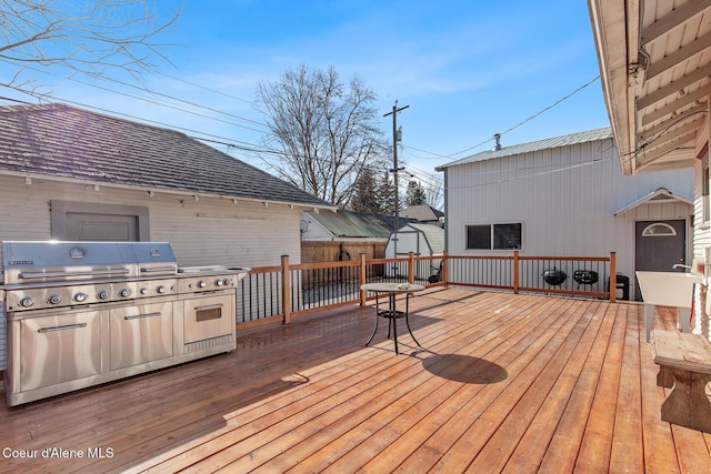 deck featuring grilling area, an outdoor structure, and a shed