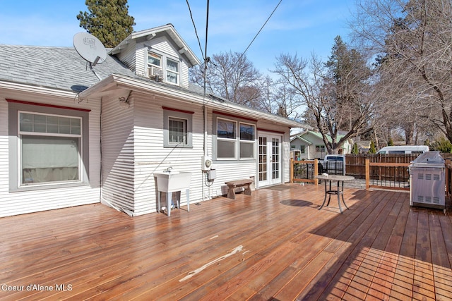 deck with a sink, french doors, area for grilling, and fence