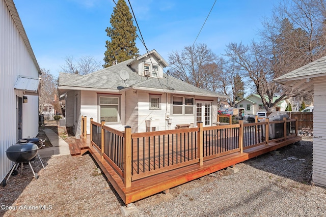 back of house featuring a shingled roof and a deck