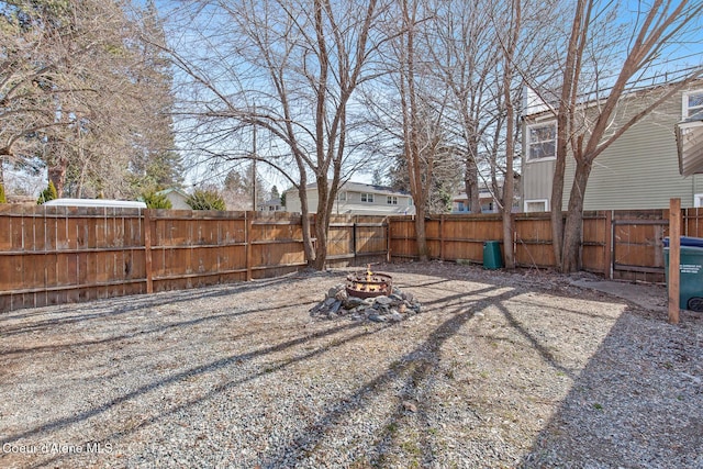 view of yard featuring a fire pit and a fenced backyard