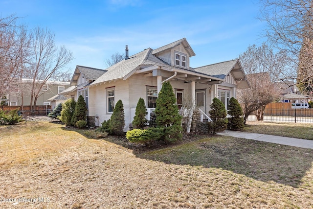 view of side of home with a yard and fence