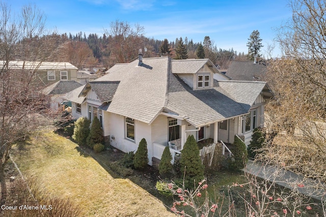 view of side of home with a lawn and roof with shingles