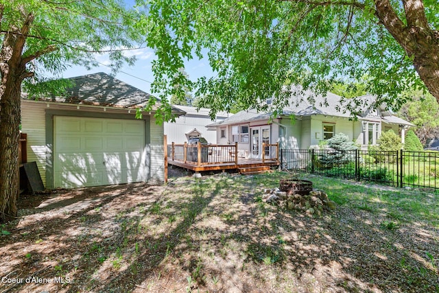 924 E Front Ave, Coeur Dalene, ID 83814 - rear view of house featuring a fire pit, a wooden deck, an outdoor structure, and an attached garage
