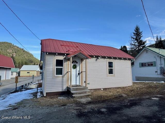 bungalow with entry steps, a mountain view, and metal roof