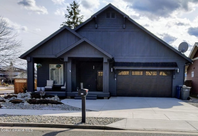 view of front facade featuring covered porch, driveway, an attached garage, and board and batten siding