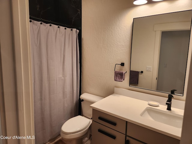 full bathroom with a shower with shower curtain, toilet, vanity, and a textured wall