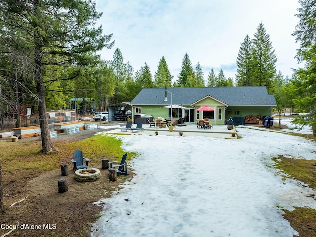 rear view of house featuring a patio, a fire pit, and driveway