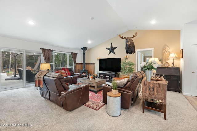 living area with light carpet, recessed lighting, a wood stove, and vaulted ceiling