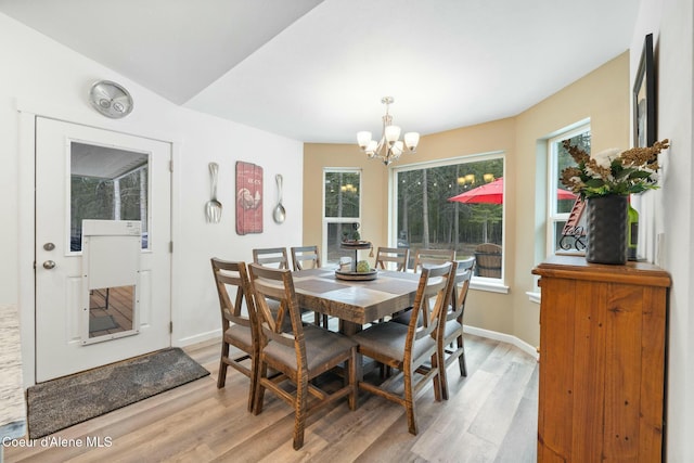 dining room with light wood-type flooring, baseboards, and a chandelier