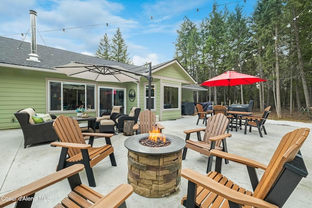 view of patio with an outdoor living space with a fire pit