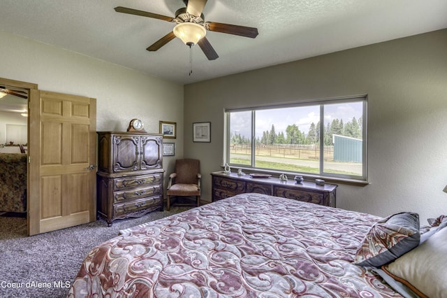 carpeted bedroom with ceiling fan, a textured wall, and a textured ceiling