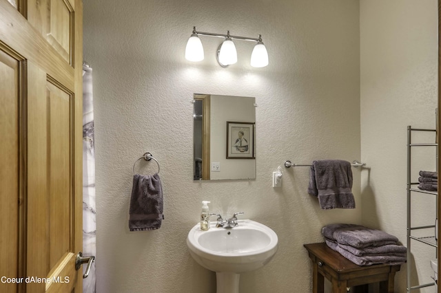 bathroom with a sink and a textured wall