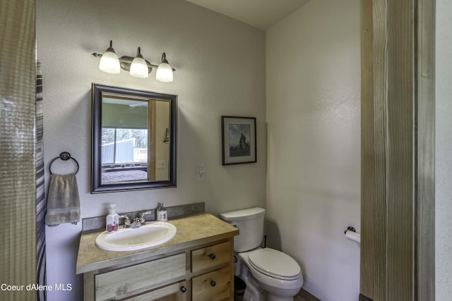 bathroom featuring toilet and vanity