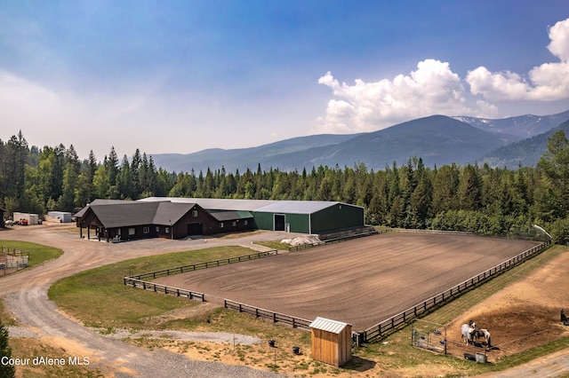 birds eye view of property with a mountain view, a view of trees, and a rural view