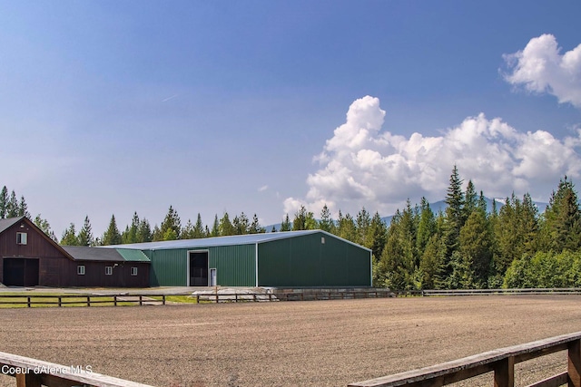 exterior space featuring an enclosed area, an outdoor structure, and a pole building