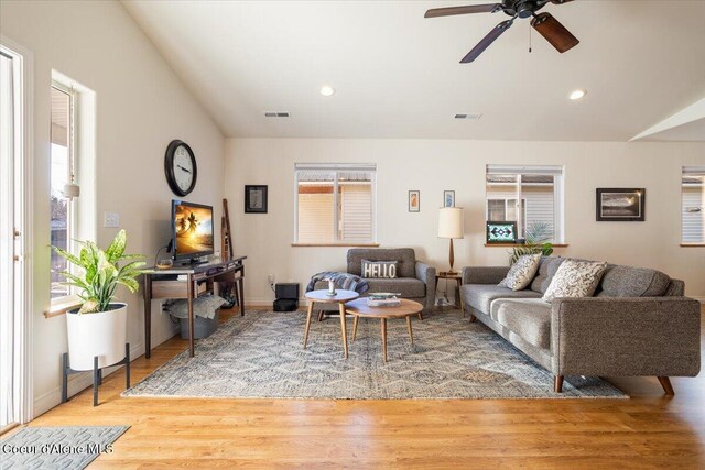 living room featuring recessed lighting, visible vents, lofted ceiling, and light wood-style floors
