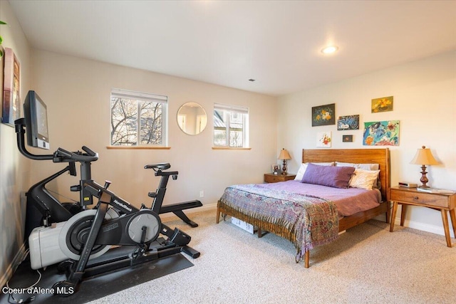 bedroom with baseboards and light carpet