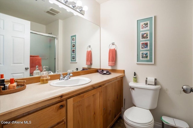 full bathroom with a shower with door, visible vents, toilet, and vanity
