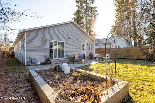 rear view of house with a yard, fence, entry steps, and a patio area