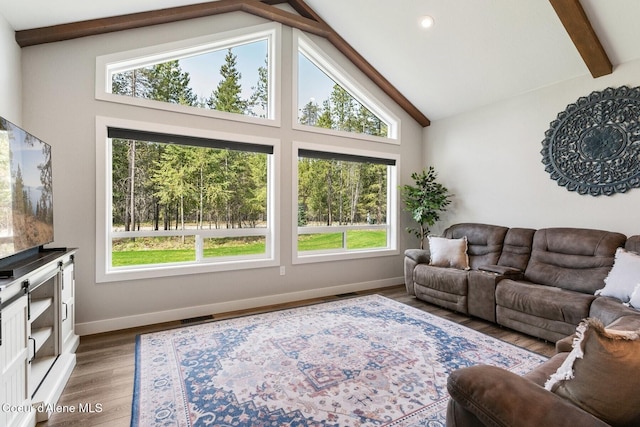 living area featuring beam ceiling, wood finished floors, baseboards, and visible vents