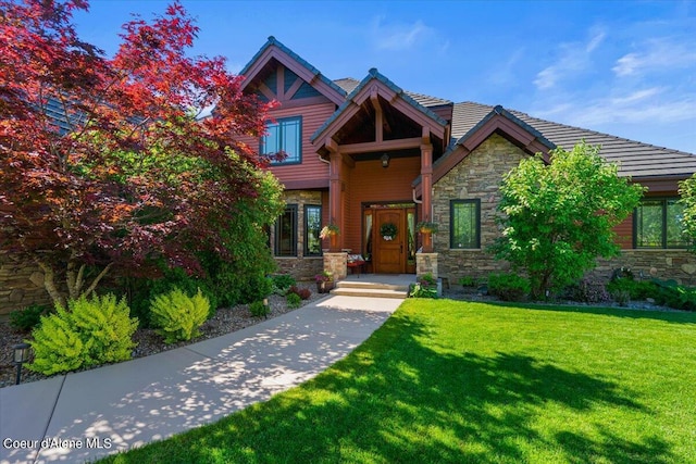 view of front of house with stone siding and a front lawn