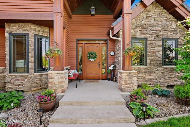 property entrance with a porch, stone siding, and crawl space