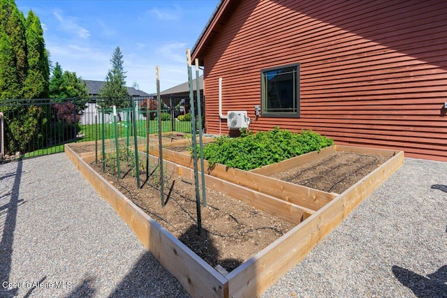 view of side of property with ac unit, a vegetable garden, and fence