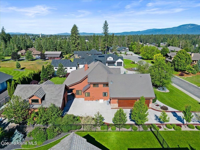 birds eye view of property featuring a view of trees, a mountain view, and a residential view