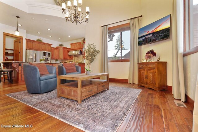 living room featuring visible vents, baseboards, recessed lighting, light wood-style floors, and a notable chandelier