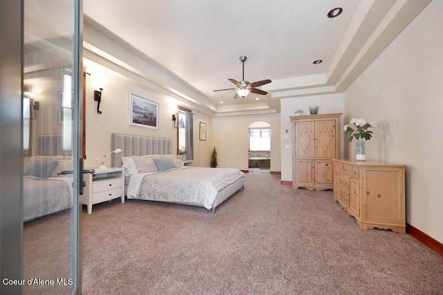 bedroom with baseboards, light carpet, recessed lighting, a raised ceiling, and a ceiling fan