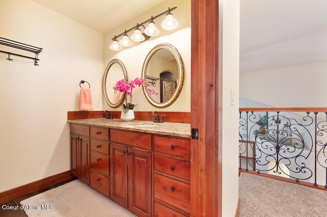 full bath featuring double vanity, baseboards, and a sink