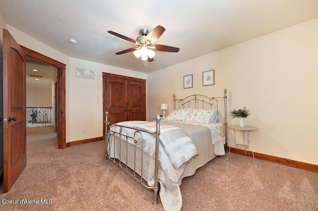 bedroom with baseboards, visible vents, ceiling fan, a closet, and light carpet