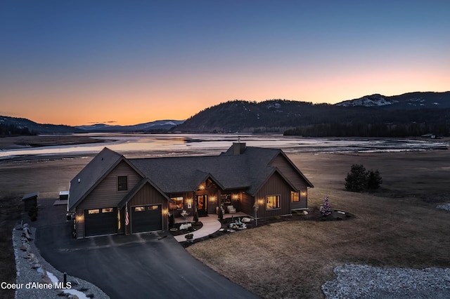 view of front of house featuring board and batten siding, a garage, a mountain view, and driveway