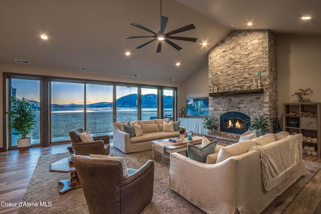 living area featuring a stone fireplace, wood finished floors, visible vents, and a mountain view