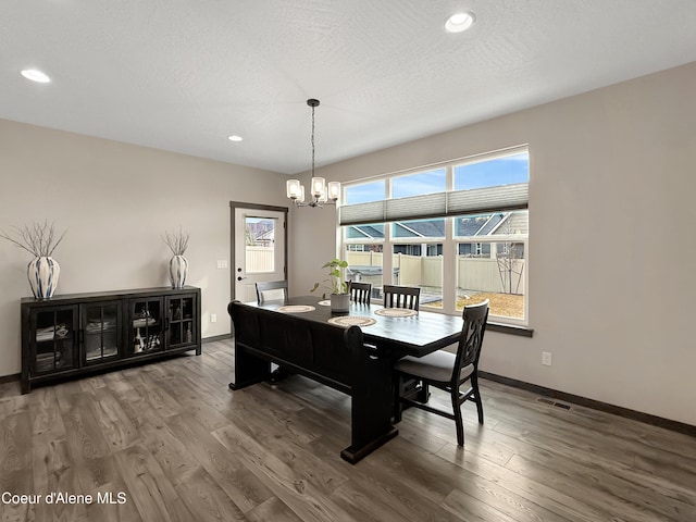 dining space featuring visible vents, baseboards, and wood finished floors