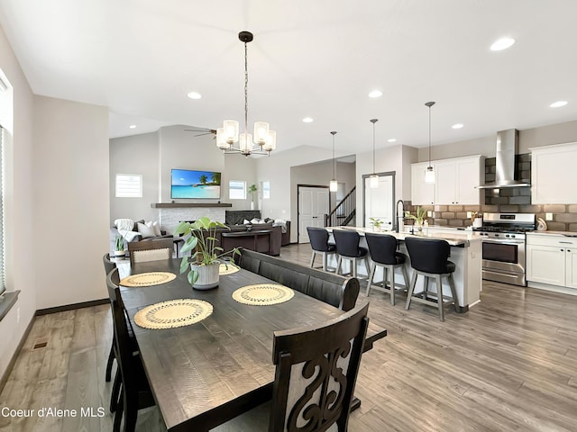 dining space featuring stairs, lofted ceiling, recessed lighting, and light wood finished floors