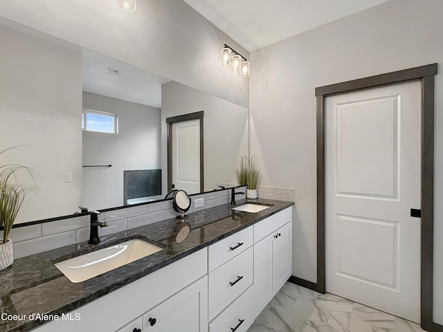 full bath with double vanity, marble finish floor, and a sink