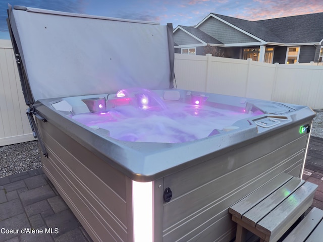 view of patio featuring a hot tub and fence