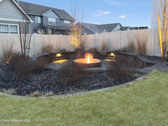 view of yard with fence and an outdoor fire pit