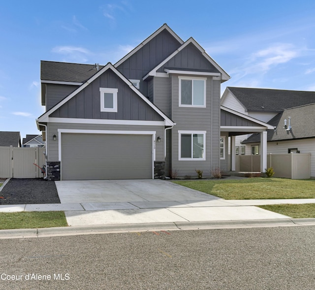 craftsman inspired home featuring a garage, board and batten siding, a front yard, and fence